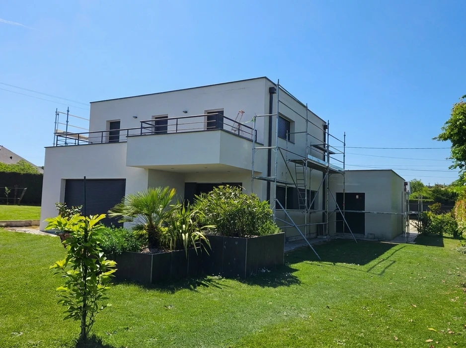 Maison contemporaine à toit plat, façade enduite blanche, deux niveaux avec terrasse à garde-corps métallique sombre
