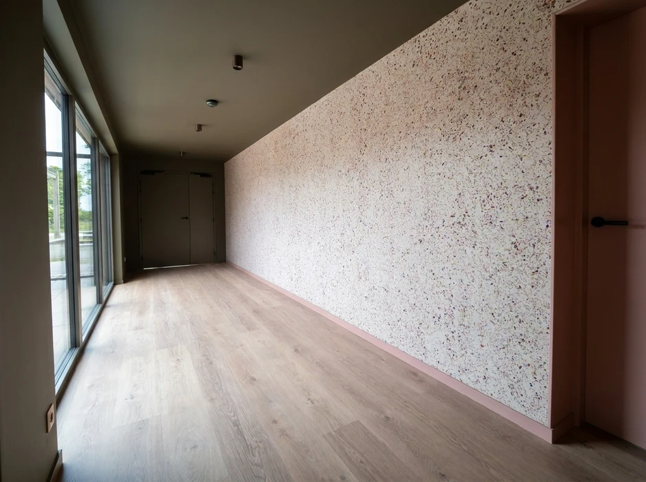 Pièce vide aux murs gris-lavande, sol en parquet stratifié chêne clair, plafond cathédrale blanc