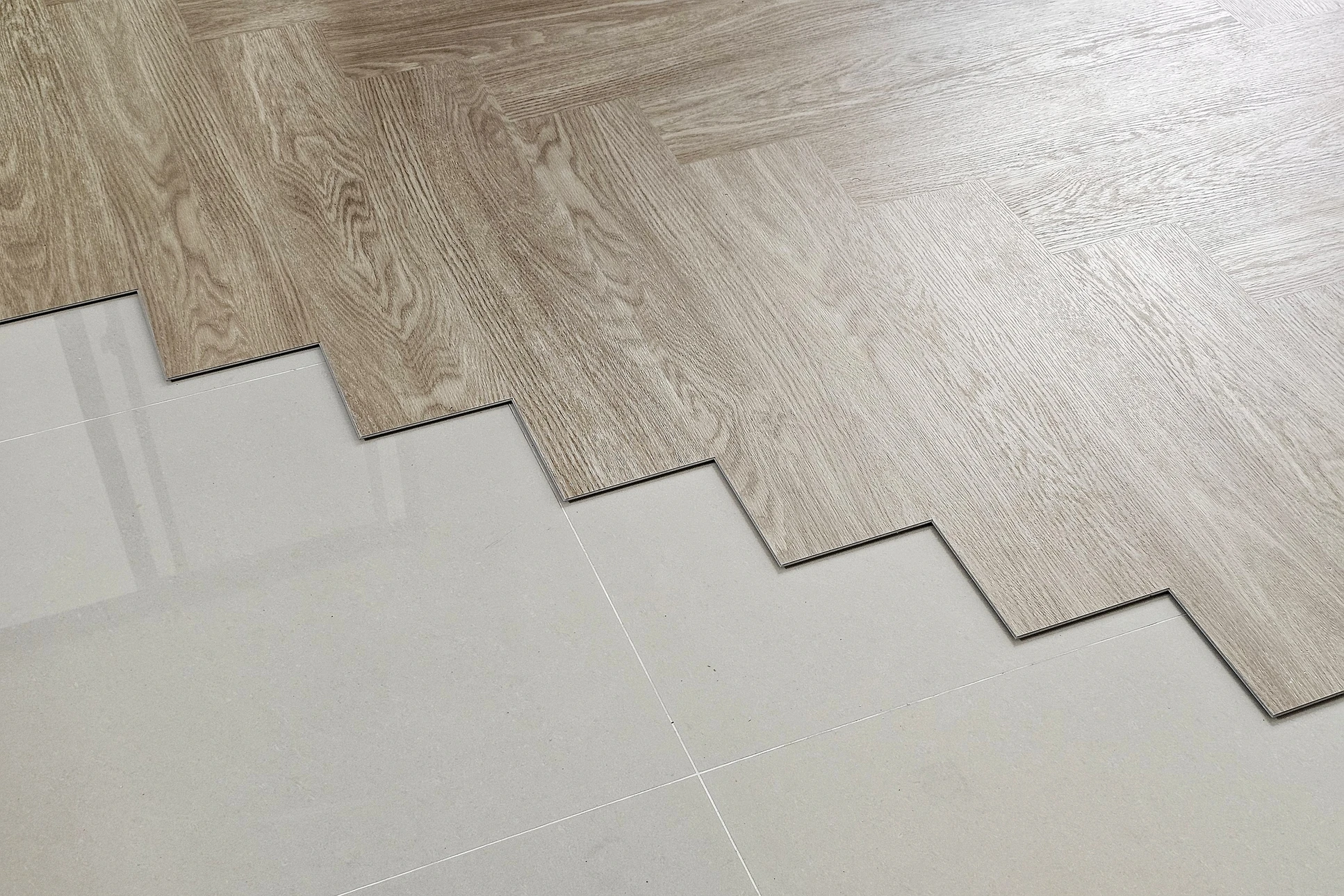 Carreleur professionnel pose des carreaux de céramique blancs sur chape avec mortier-colle
